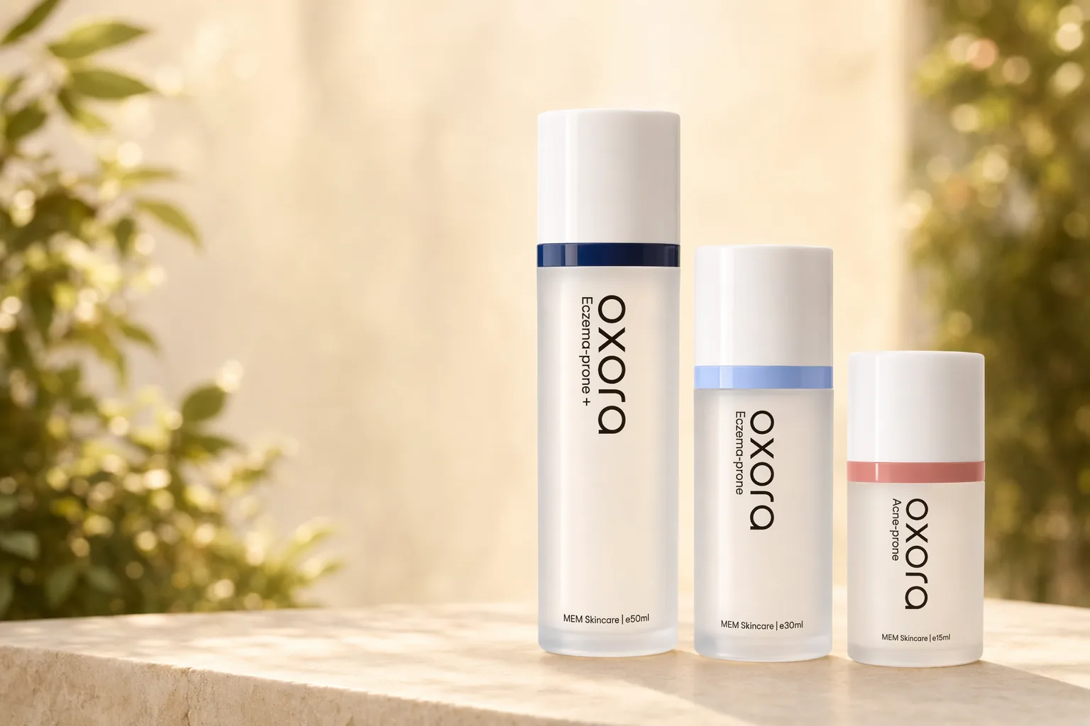 Oxora Acne-prone, Eczema-prone and Eczema-prone Plus Skin Base Fluid in 15 ml, 30 ml and 50 ml airless pump bottles, on a sunlit ledge