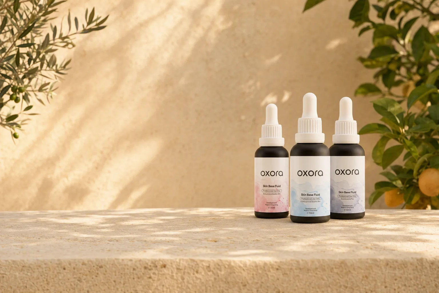 Oxora Acne-prone, Eczema-prone and Eczema-prone Plus Skin Base Fluid in 30 ml and 50 ml glass dropper bottles, on a sunlit limestone ledge in a garden